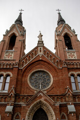 Architectural styles of the Catholic Church, view from below. Fragment of the decoration of the church in the neo-Gothic style. Roman Catholic church made of brick in the neo-Gothic style
