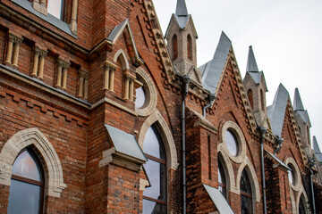 Architectural styles of the Catholic Church, view from below. Fragment of the decoration of the church in the neo-Gothic style. Roman Catholic church made of brick in the neo-Gothic style