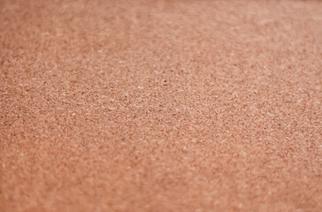 The brown-yellow color of the cork board. Textured wooden background