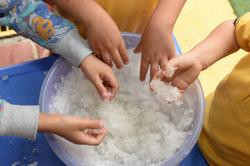 Infant sensory stimulation therapy: Several children place their hands in sodium polyacrylate to...