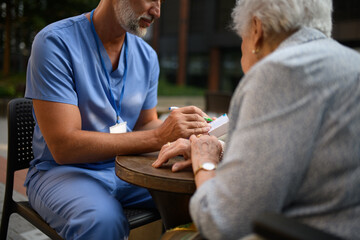Doctor explaining medication to senior patient and answering her questions.