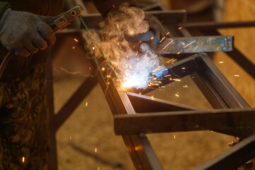 A man is welding metal with a piece of equipment