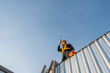 A team of technicians with equipment works to inspect the roof structure for the installation of architectural and systems in roof. Employees in the safety team carry out inspection and repair work.