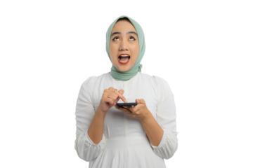 Excited young Asian woman in green hijab and white blouse pressing her finger on smartphone and looking up with amazed expression isolated on transparent background