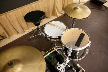 A drum set with a black seat and a white drum