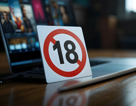 Laptop Computer with Age Restriction Sign on Wooden Table