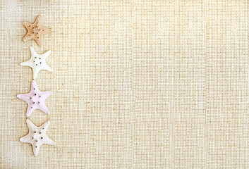 Vacations background with four starfishes on canvas texture. Topic of vacation, travel, trip abroad...