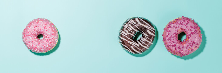A colorful assortment of vibrant donuts with various toppings arranged on a blue
