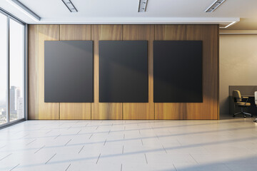 Three blank black posters on wood-paneled wall in modern office interior with tiled floor and city view through large glass windows. 3D Rendering