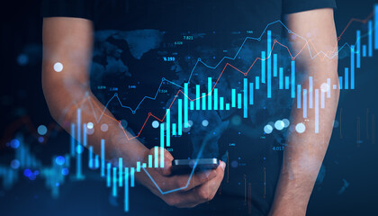 Businessman using smartphone with glowing financial charts and bar graphs overlay on dark abstract background representing digital data analysis.