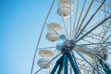 Ferris wheel towering against a clear blue sky during a sunny day.