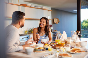 Multiethnic couple enjoying breakfast at home