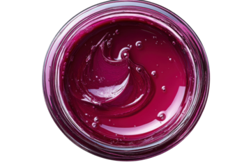 Bright purple gel in a clear glass jar situated on a white background