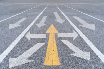 Yellow arrow facing opposite direction white arrows on asphalt street road. Different Thinking.
