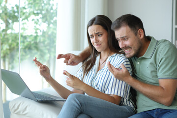 Worried couple crossing fingers waiting for online result