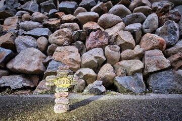 Cross made up of stones with the names of Jesus Christ printed on them.