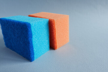 Colorful sponges for washing dishes on a blue background.