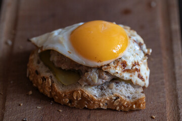 schnitzel sandwich with scrambled eggs from one egg, close-up of an egg yolk, lunch sandwich, top view