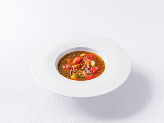 Traditional Italian minestrone soup with fresh vegetables, beans, and pasta in a rich tomato broth. Served in a white bowl on a clean white background, highlighting the vibrant colors and textures of