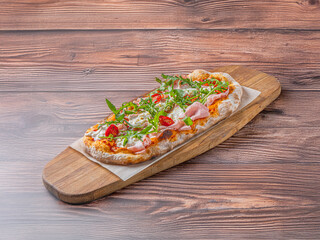 Italian pizza with mozzarely and dilapidated muzzle with a pistachio on a wooden board. 