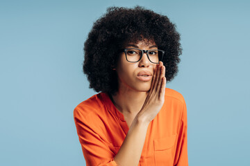 Young Latin woman whispering secret sharing gossip on blue background