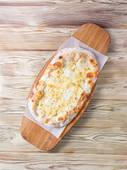 pizza 4 cheese on a wooden board cooked in a wood stove.Centered composition .Top view.