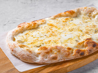 pizza 4 cheese on a wooden board cooked in a wood stove.Centered composition .Top view.Close-up Macro shot