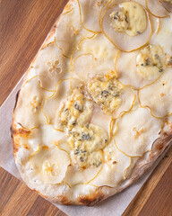 pizza 4 cheese on a wooden board cooked in a wood stove.Centered composition .Top view.Close-up Macro shot