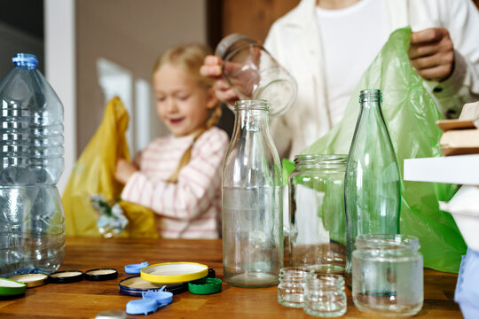 Father, daughter,home, glass jars, plastic bottles, Sustainability, waste sorting, environmental responsibility, teamwork