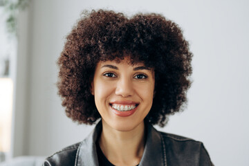 Fototapeta premium Portrait of African American woman smiling with braces and afro hairstyle