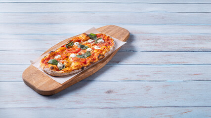 Classic Margherita pizza with a thin, crispy crust, rich tomato sauce, melted mozzarella, and fresh basil leaves. Served on a rustic wooden board with a warm, textured background, emphasizing its