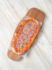 Pizza Cipolla. Italian pizza from a stove with tomato sauce red onions and Mozarella. Pizza on a wooden board