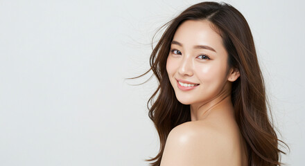 髪を風になびかせ振り向く若い女性（美容、ビューティー、化粧品、、スキンケア、健康）