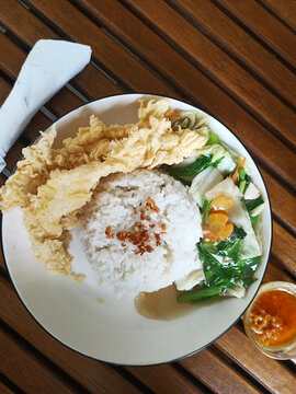 A simple yet satisfying meal: Crispy fried chicken, fluffy white rice, and a medley of stir-fried vegetables.