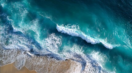 Aerial view of deep blue ocean waves creating white foam patterns as they move toward shore