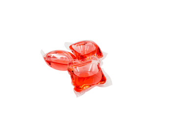 Capsules with detergent for washing machine, isolated on a white background. Red gel Capsules