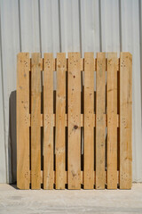 Wooden Pallet Leaning Against a Metal Wall in Industrial Setting