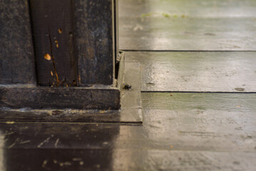 close up of a black wooden beam which is attached with metal to a black wooden table as well