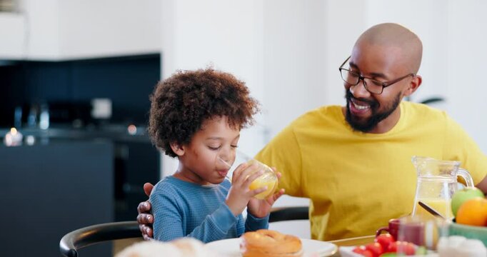 Father, child or communication with orange juice by table, for lunch or nutrition with happiness in family home. African, dad or son with sip drink, vitamin c or fruit for health wellness at dinner
