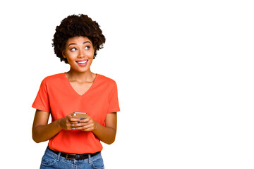 Copyspace photo of cheerful curly wavy trendy woman holding telephone with her hands wearing jeans...