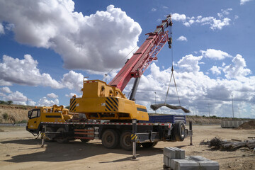 Fototapeta premium Mobile Crane Lifting Heavy Rebar Bundle at Construction Site