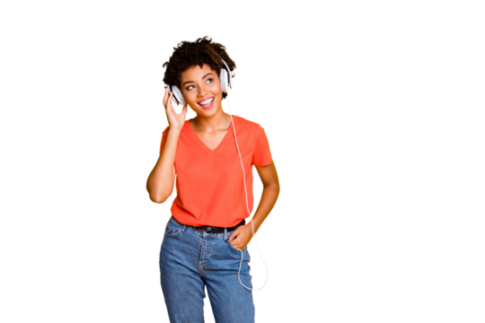 Photo of curly wavy trendy cheerful cute nice charming attractive black girlfriend wearing jeans denim t-shirt listening to music in earphones while isolated over yellow vivid color background