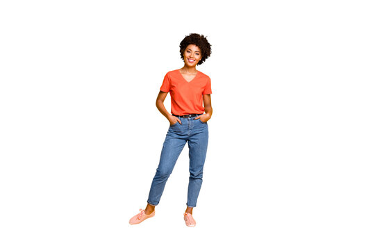 Full length body size photo of cool swag good black millennial girl posing in front of camera showing her coolness wearing jeans denim sneakers isolated over vibrant color background