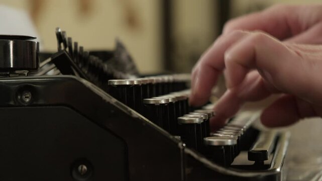 Woman typing on old vintage typewriter close up side view