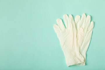 Obraz premium Medical nitrile gloves,blue cap, disposable medical mask on textured background. Medic protective clothing. Surgical latex gloves. Rubber gloves manufacturing.Medicine concept. Top view. Copy text