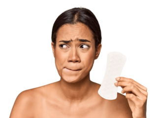 Filipino woman with sanitary pad in studio confused, feels doubtful and unsure.