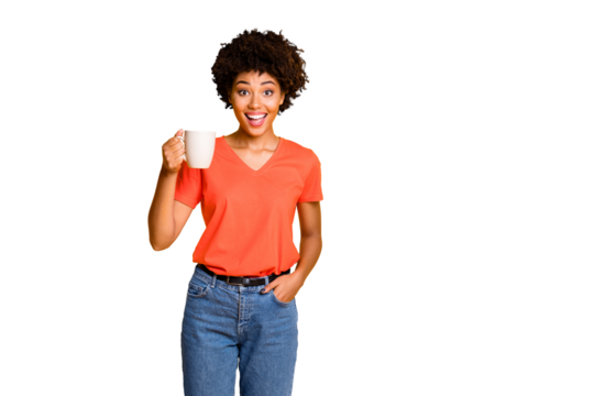 Photo of charming cute cheerful nice attractive girlfriend wearing orange t-shirt denim jeans holding cup of tea isolated over yellow vivid color background