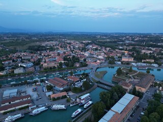 Obraz premium Cityscape Panorama at Dusk: An expansive aerial perspective captures a picturesque city as twilight descends, with the urban landscape, illuminated buildings, and surrounding natural beauty.