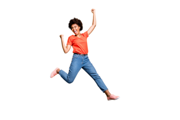 Full size photo of crazy funky delighted lady jump celebrate victory in lottery raise her fists scream yeah wear red t-shirt denim jeans sneakers isolated over yellow color background