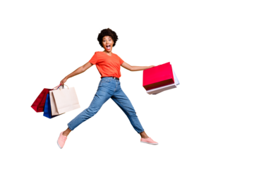 Full size photo of funny excited amazed shocked brunette curly girl hold bags on travel have bargains jump run wear red t-shirt denim style stylish trendy jeans isolated over yellow color background